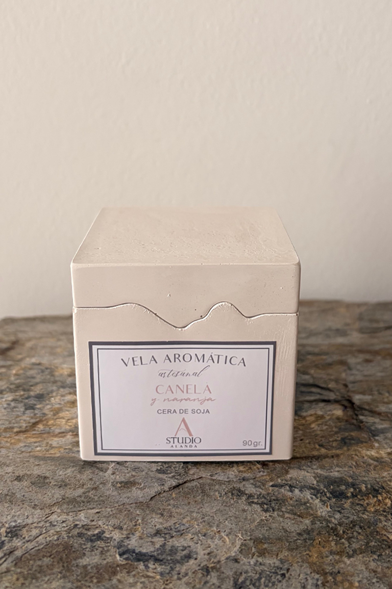 vela de soja aromática con aroma a canela y naranja en recipiente artesanal montañas